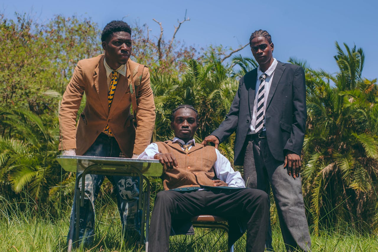 Stylish young men in suits pose confidently outdoors in Accra, Ghana.